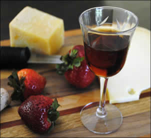 Glass of sweet Vinsanto wine with fruit and cheese