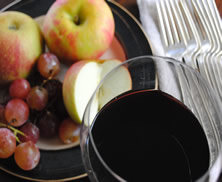 Glass of red wine with fruit plate.