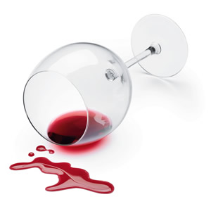 Wine glass laying on its side with spilled red wine