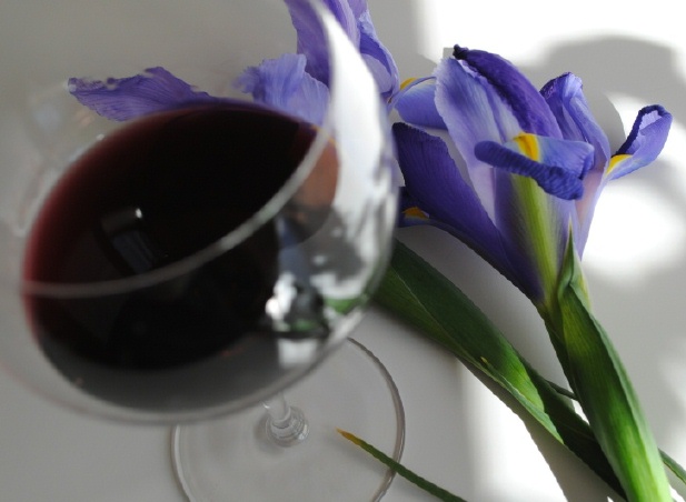 Glass of red wine with iris in background