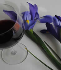 Red wine glass with iris in background